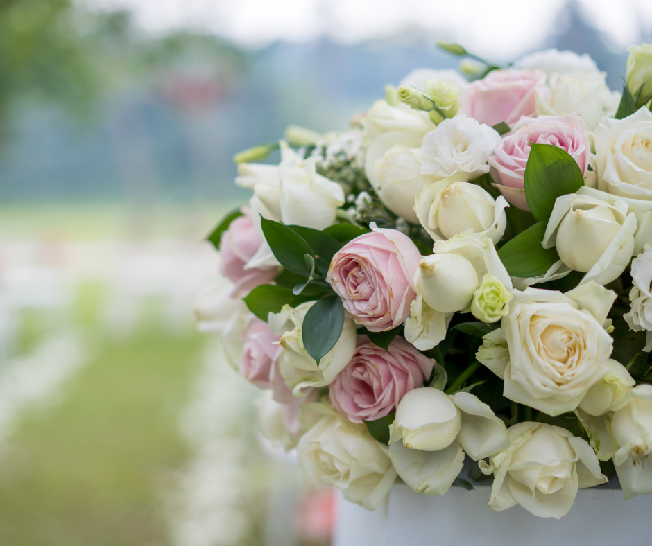 picture of wedding flowers in foreground of outdoor wedding
